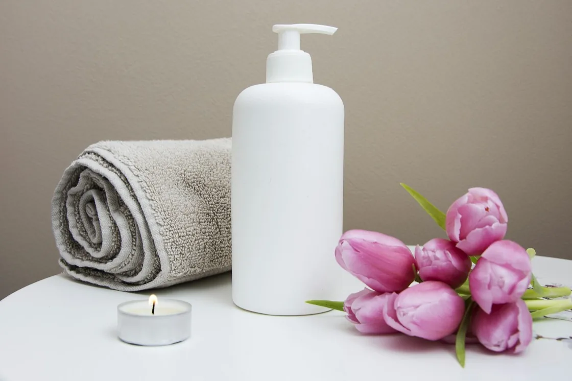 Rolled towels, a candle and pink tulips in the salon